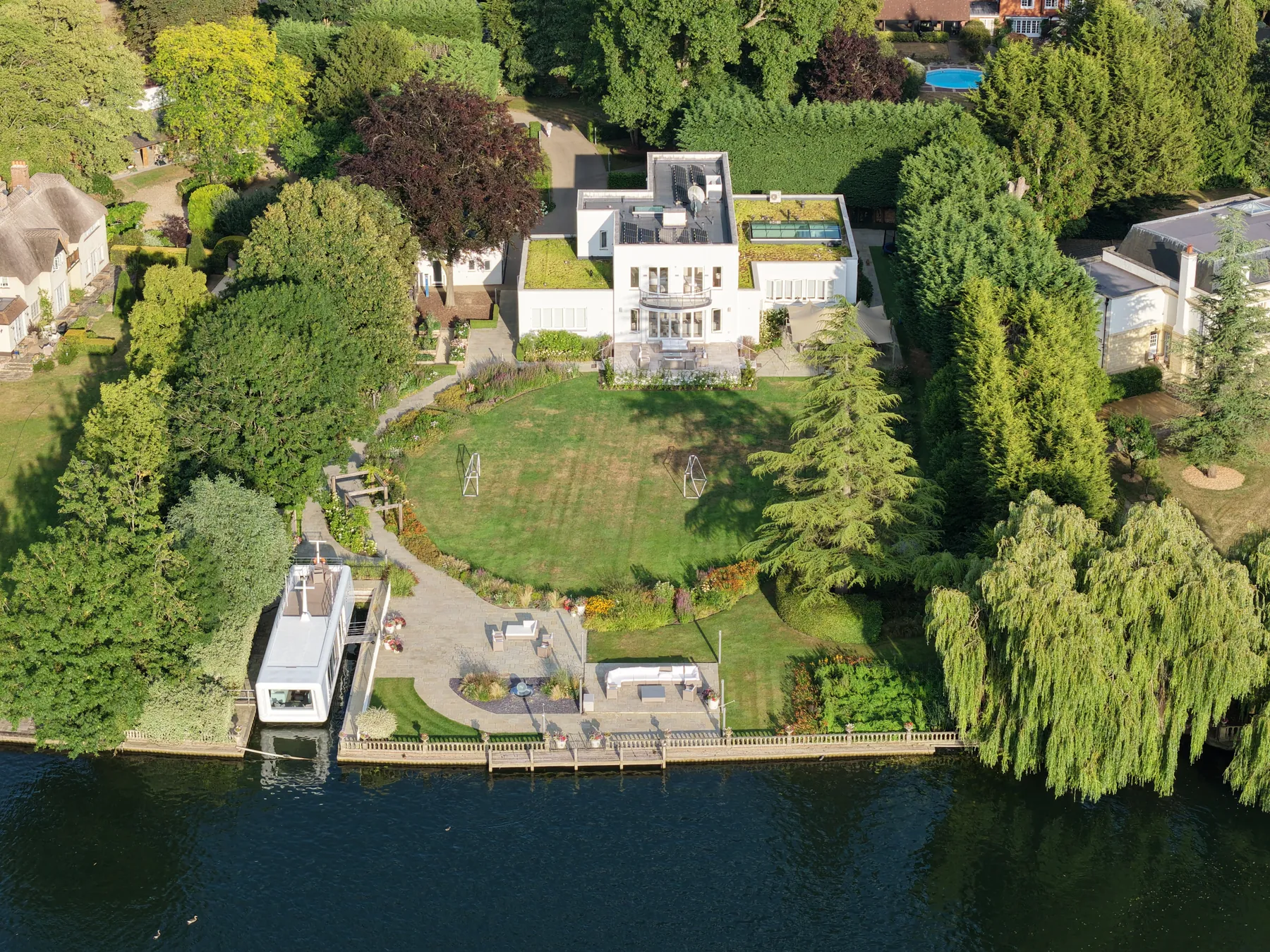 An aerial view of a riverside villa and its grounds