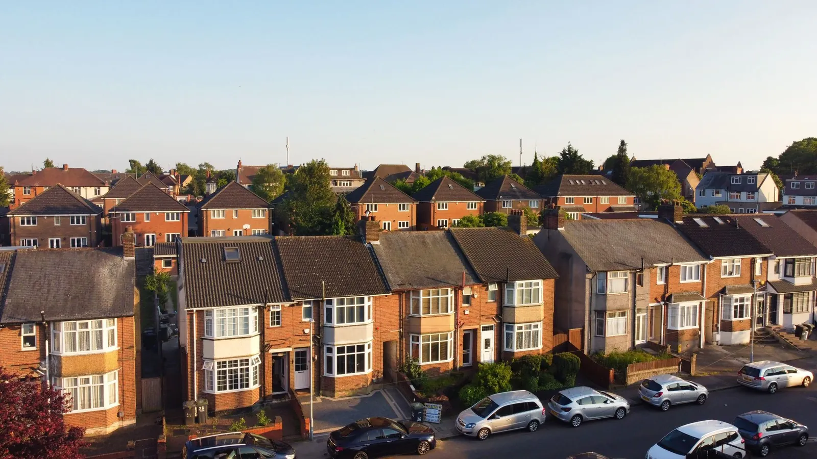 Rooftops along a street of UK suburban houses, seen from the air